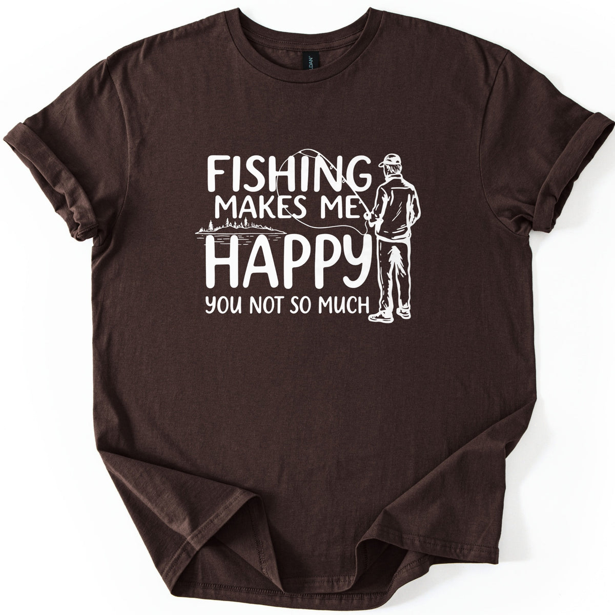 Fishing Makes Me Happy Comfort Colors T-shirt in Dark Chocolate, laid flat. White print reads Fishing Makes Me Happy, You Not So Much, next to a drawing of a man in a cap, seen from behind, holding a fishing rod near a tree-lined lake. Shown with rolled sleeves on white.