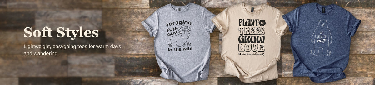 Lightweight Gildan Softstyle graphic tees, including a camper design, against rustic barnwood